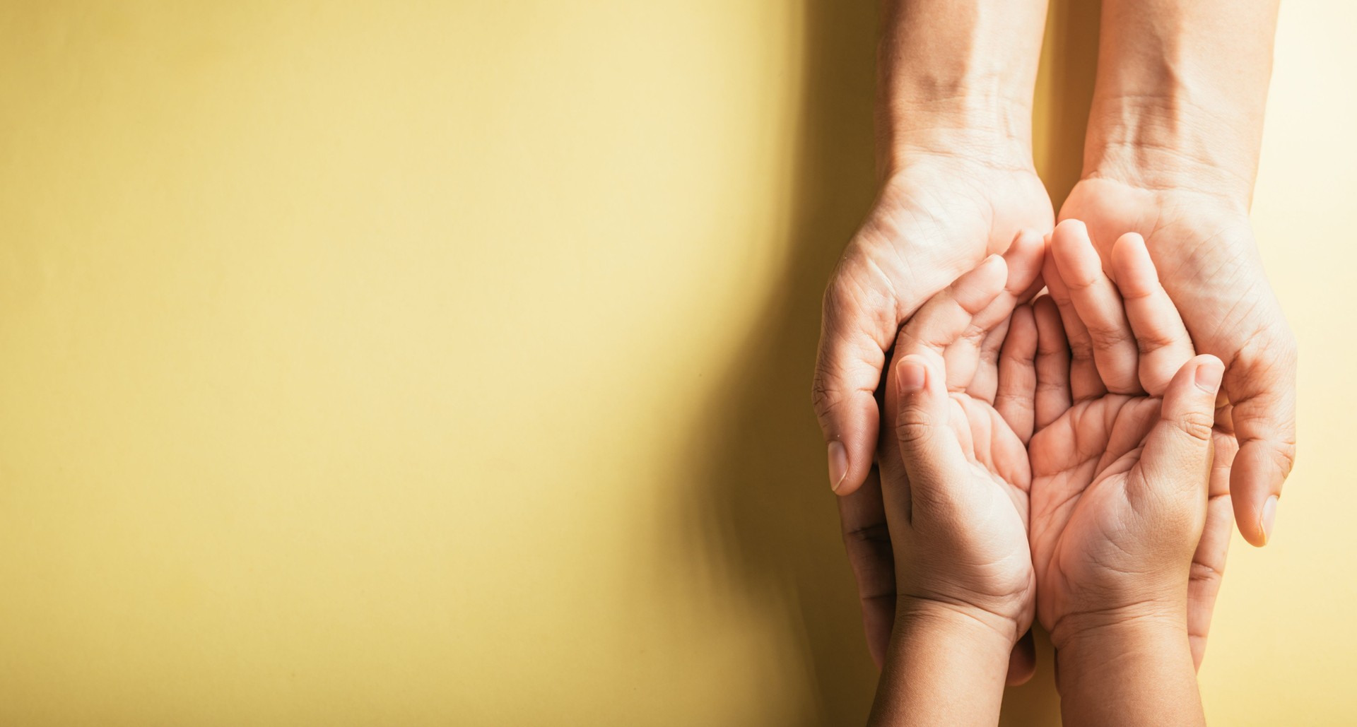 Top view of family hands stacked isolated background. Parents and child holding empty space a gesture of support and love on Family and Parents Day. Concept of togetherness and trust.